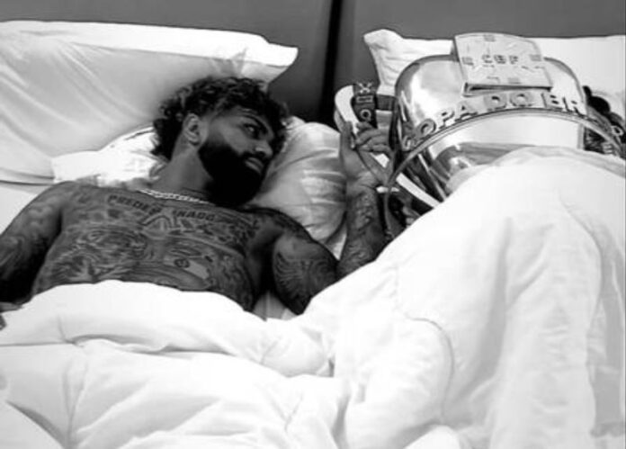 Gabigol posa na cama com a taça da Copa do Brasil após festas